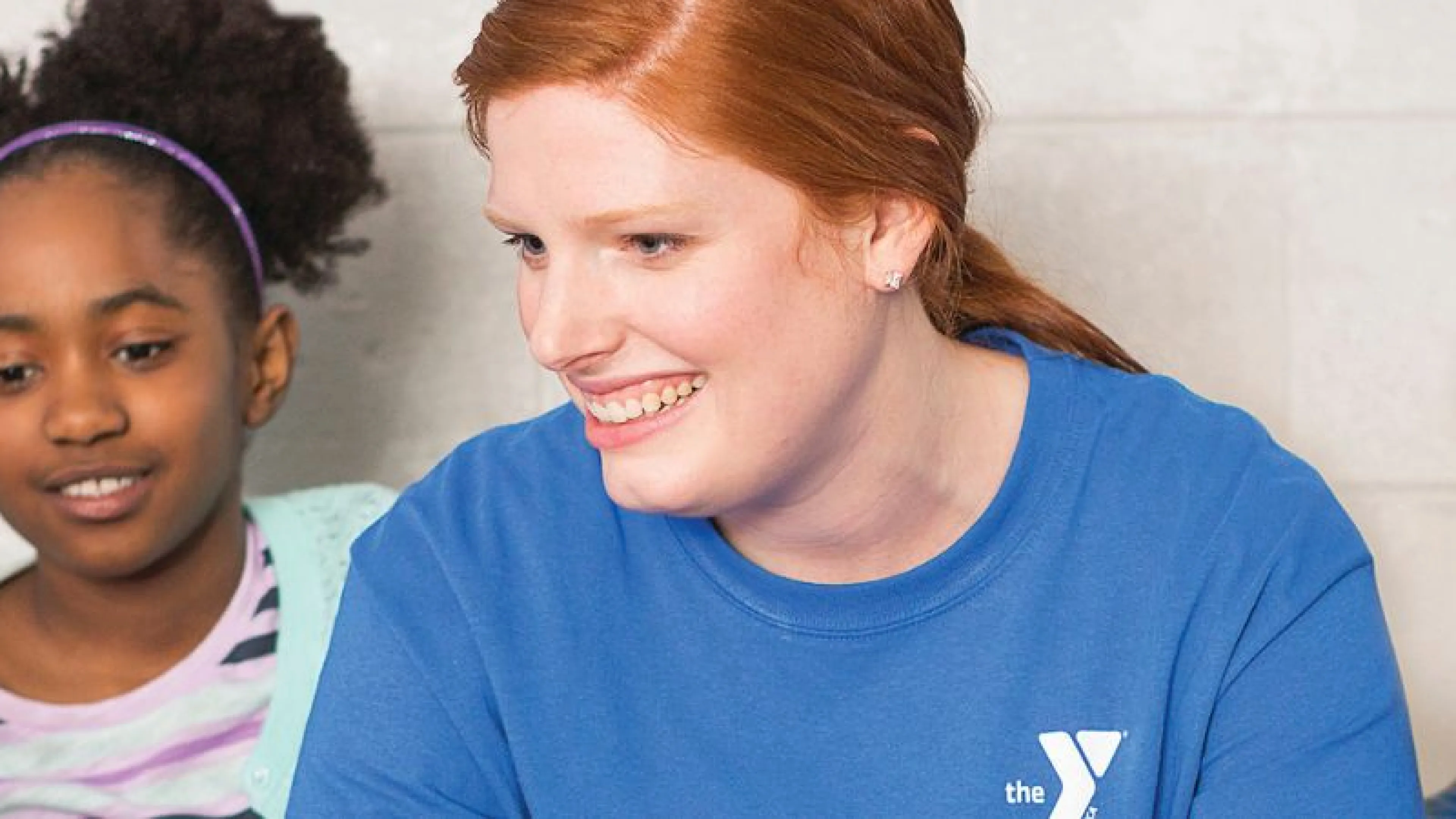 Y volunteer talking to young kids