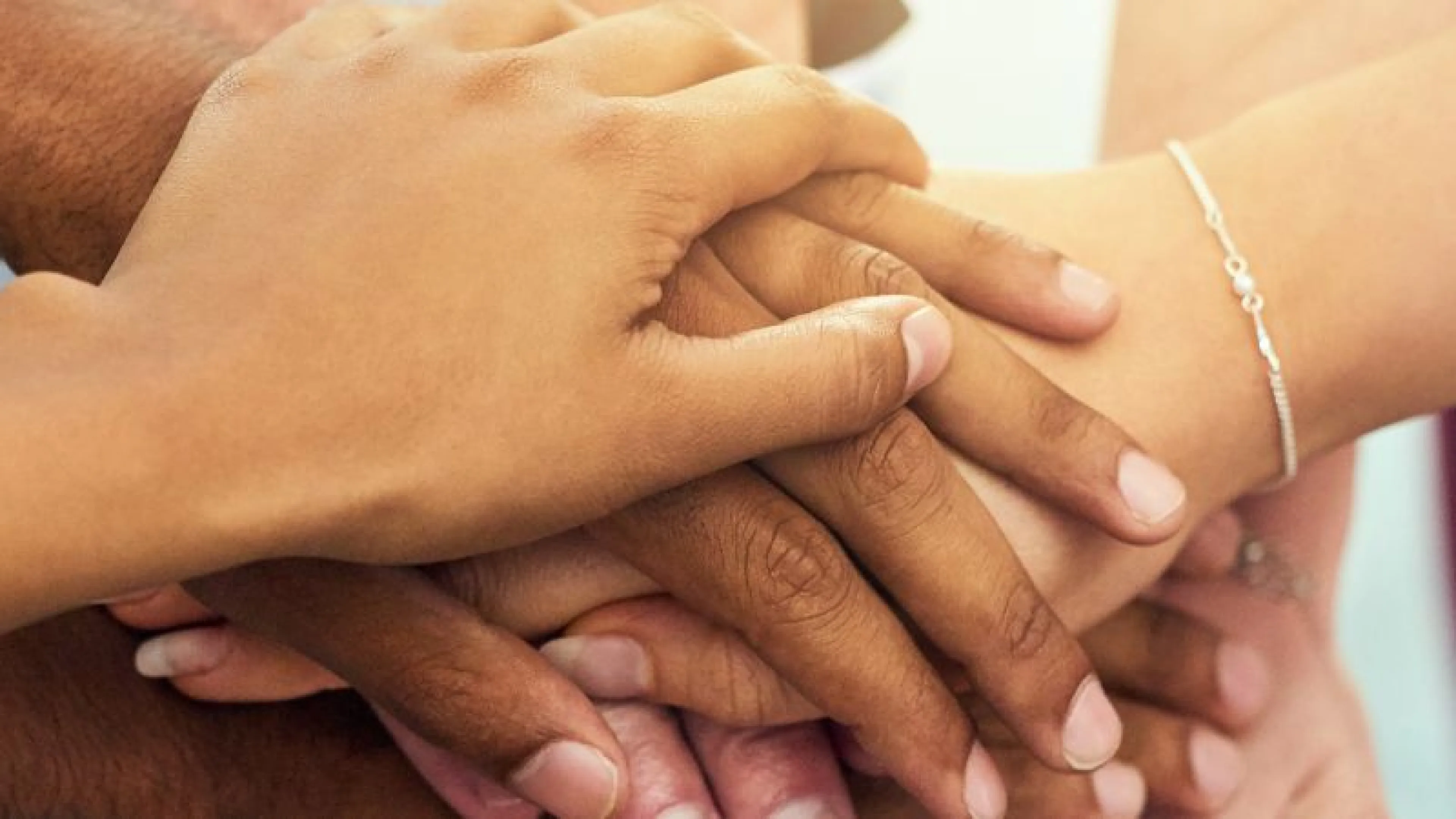 group of hands stacked on top of each other